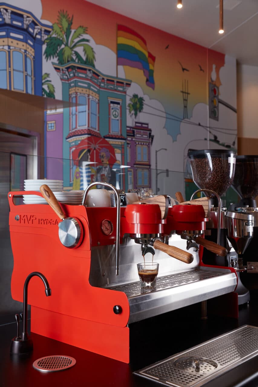 Espresso machine in front of mural